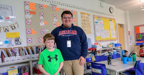 Jesse Lima, right, stands next to his student, Andrew Deal, at Janney Elementary School. Photo by Jeff Watts.